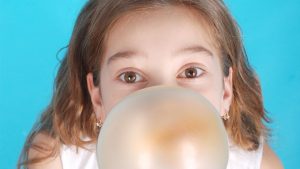 Mädchen macht eine Kaugummiblase