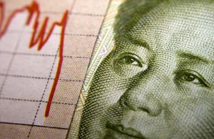 Chinesischer Geldschein neben fallendem Kursverlauf